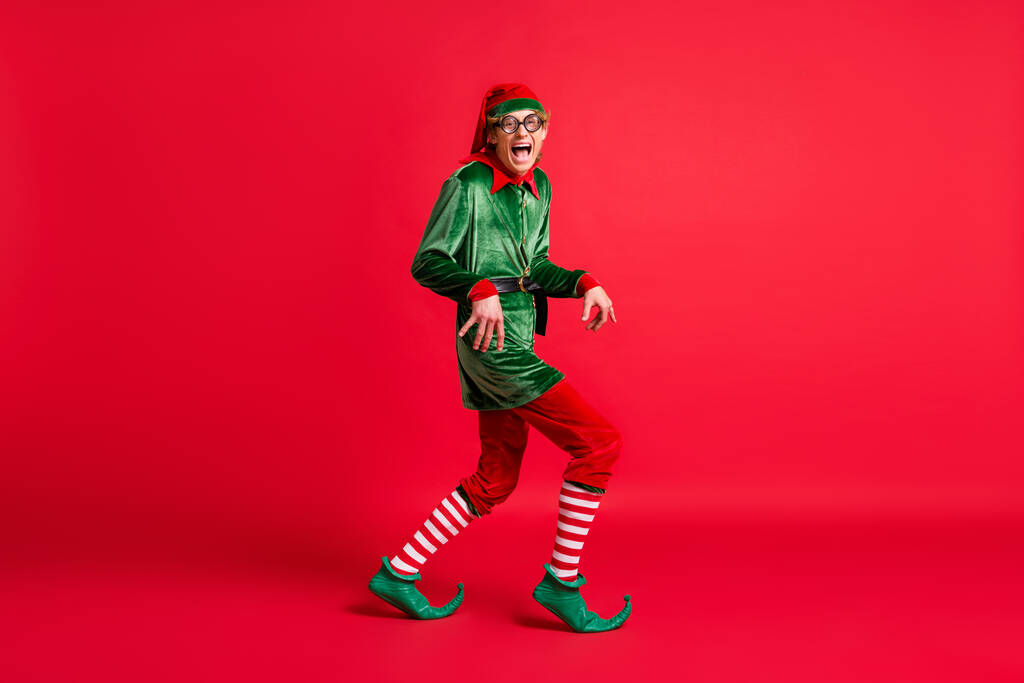Profilo completo del corpo foto laterale di folli elfo cattivo sneak x-mas copyspace indossare cappelli di Natale isolati su sfondo colore lucentezza - Foto, immagini