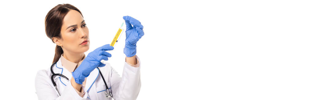 Vaakasuora kuva lääkäristä, joka pitelee ruiskua, jossa on kovapintainen rokotekaiverrus valkoisella - Valokuva, kuva