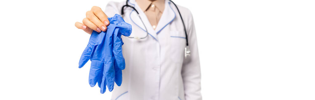 Панорамный снимок доктора, показывающего латексные перчатки на камеру, изолированную на белом - Фото, изображение