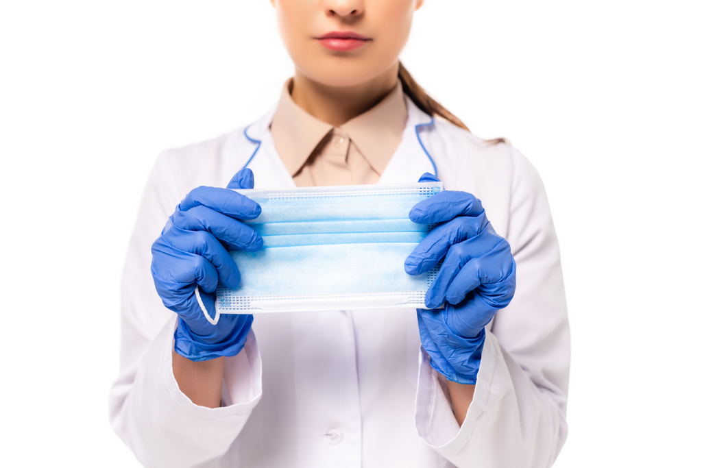 Cropped view of doctor holding medical mask isolated on white - Photo, Image