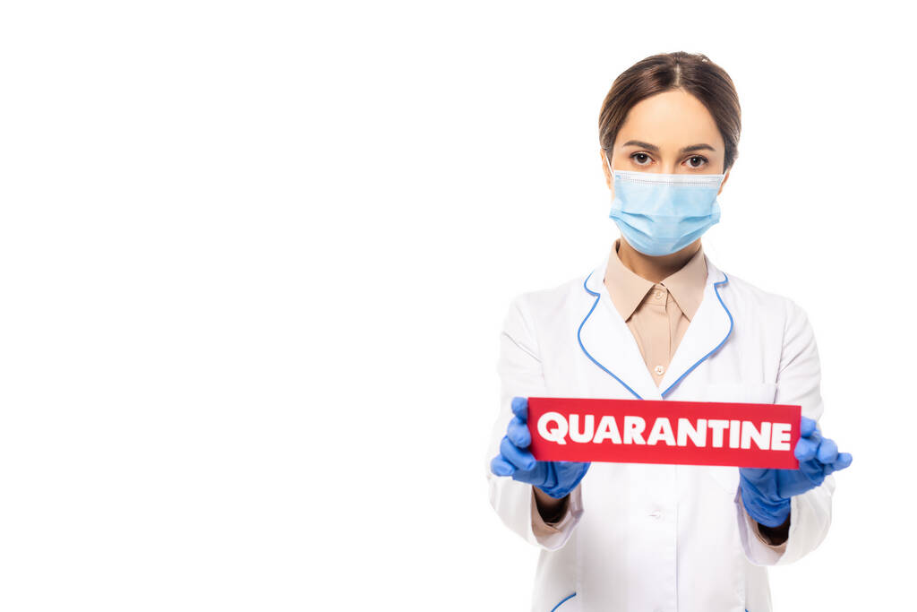 Arts in medisch masker en witte jas met quarantaine letters geïsoleerd op wit - Foto, afbeelding