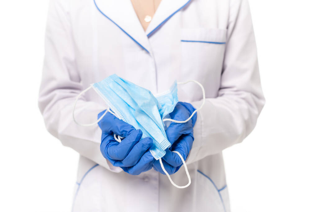 Vista ritagliata del medico in guanti di lattice con maschere mediche isolate su bianco - Foto, immagini