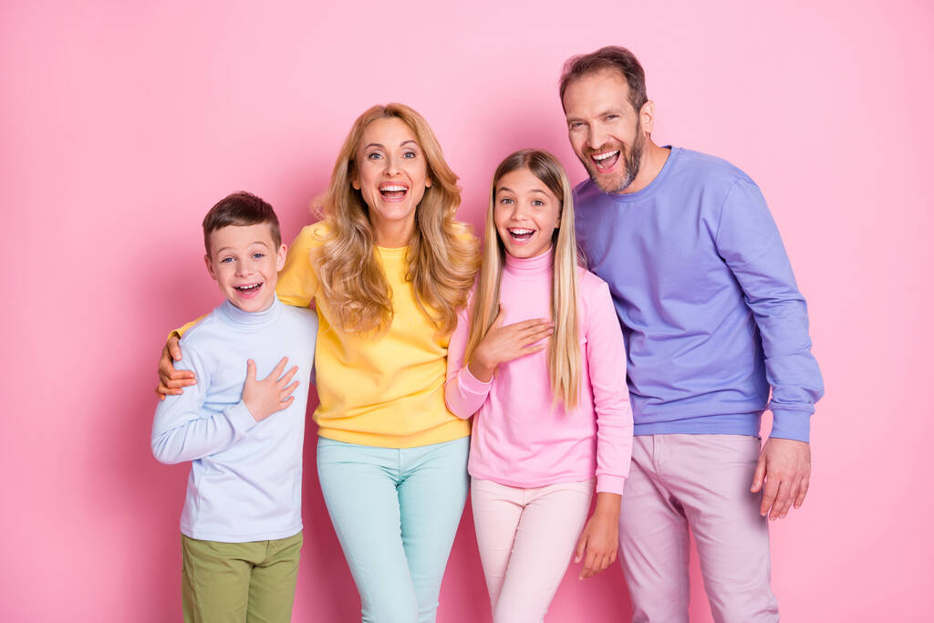 Фото позитивної веселої сім'ї, яка дивиться в камеру, сміється ізольовано на пастельному кольоровому фоні
 - Фото, зображення