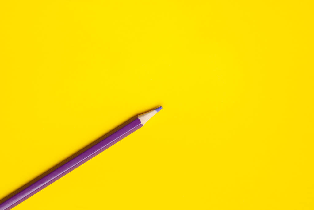 lápis de madeira afiada roxo diagonal em um fundo amarelo brilhante, isolado, espaço de cópia, mock up - Foto, Imagem