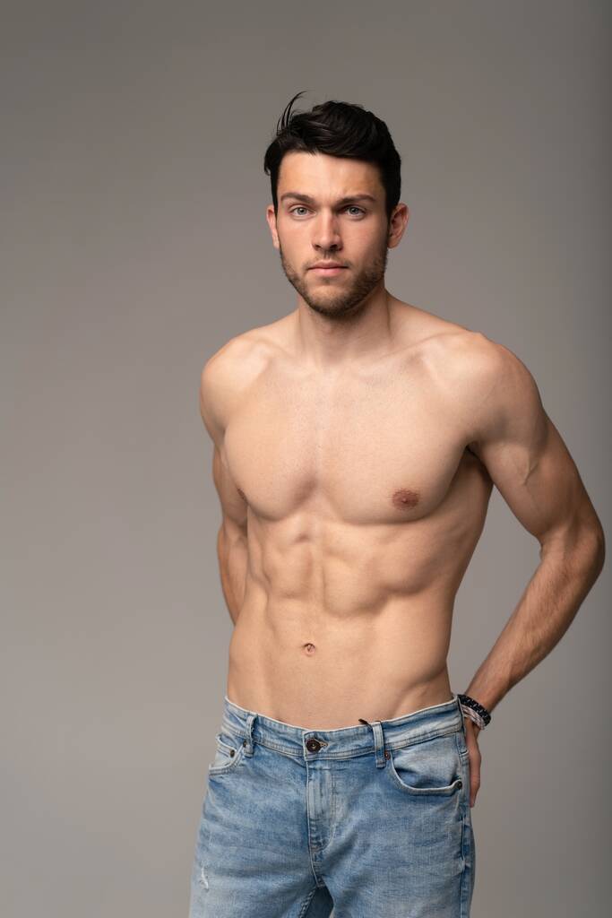 Porträt eines gut gebauten, schulterfreien, muskulösen männlichen Modells vor weißem Hintergrund. - Foto, Bild