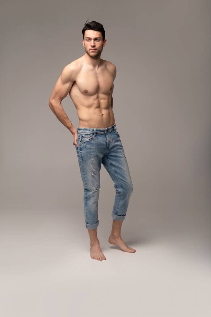 Portrait of a well built shirtless muscular male model against white background. - Photo, Image