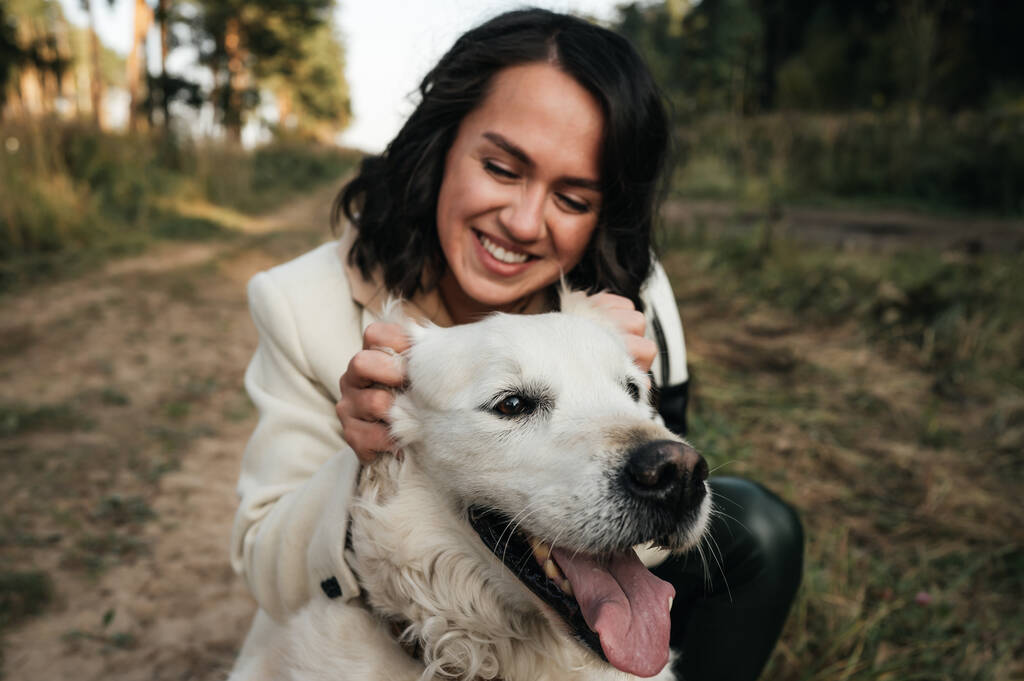дівчина обіймає золотого собаку-ретривера в полі
 - Фото, зображення
