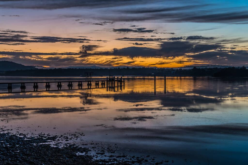 Paisaje acuático al amanecer con nubes altas, muelle y reflejos en Woy Woy Waterfront en la costa central, NSW, Australia. - Foto, Imagen