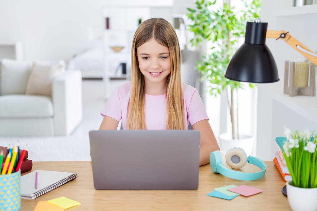 Photo of positive kid girl study remote sit desk table use laptop volna online kommunikációs lecke tutor írás jelentés a házban beltéri - Fotó, kép