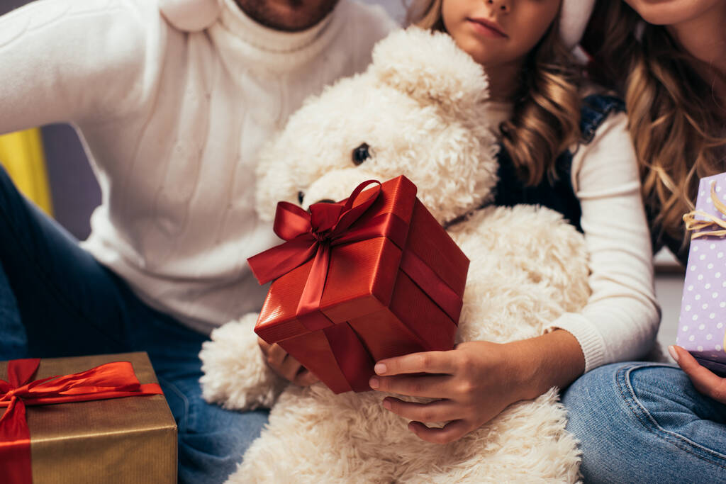 обрезанный вид ребенка с рождественскими подарками рядом с родителями - Фото, изображение