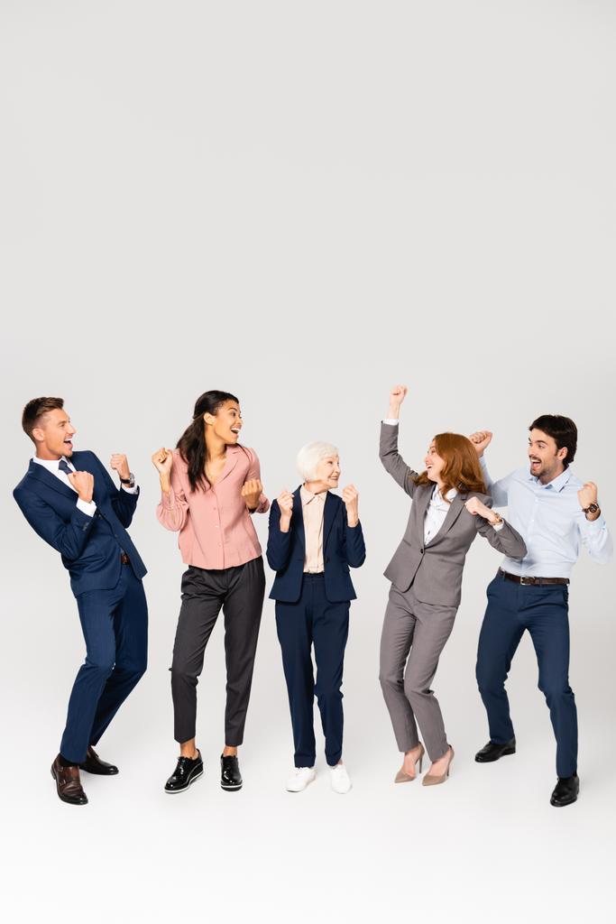 Позитивні багатокультурні бізнесмени показують так жест на сірому фоні
 - Фото, зображення