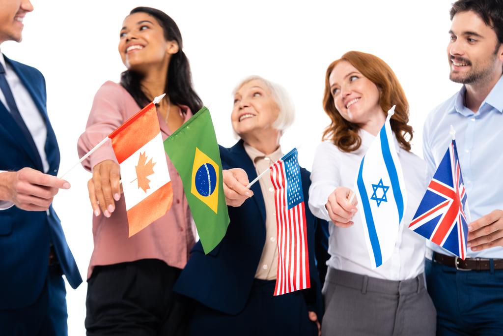 Flaggen von Ländern in den Händen multiethnischer Geschäftsleute auf grauem Hintergrund isoliert auf weißem Hintergrund - Foto, Bild