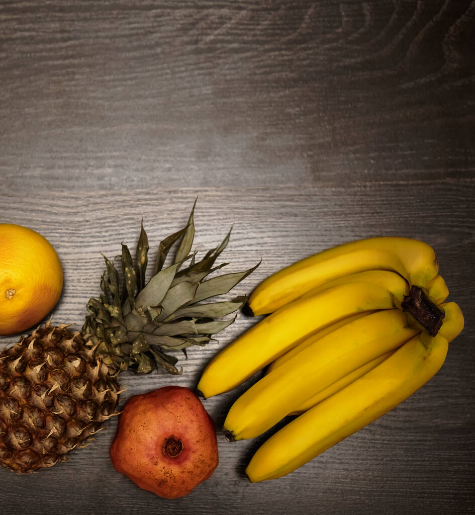 Ananas, banane su fondo di legno nero. Frutta tropicale. ingredienti per frullato - Foto, immagini
