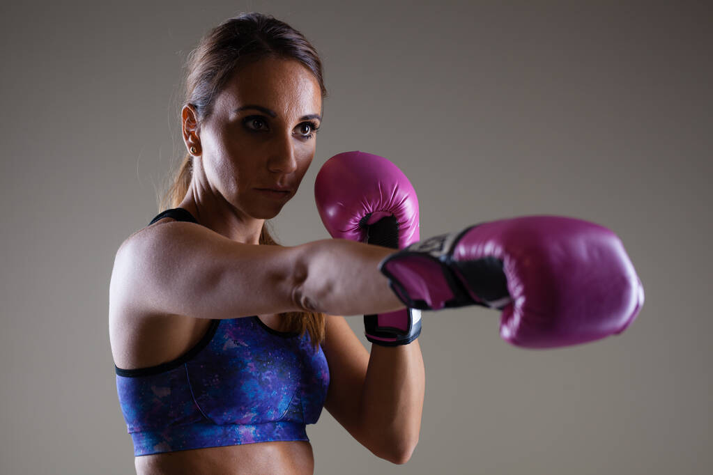 chica kickboxer posando con guantes rosados - Foto, Imagen