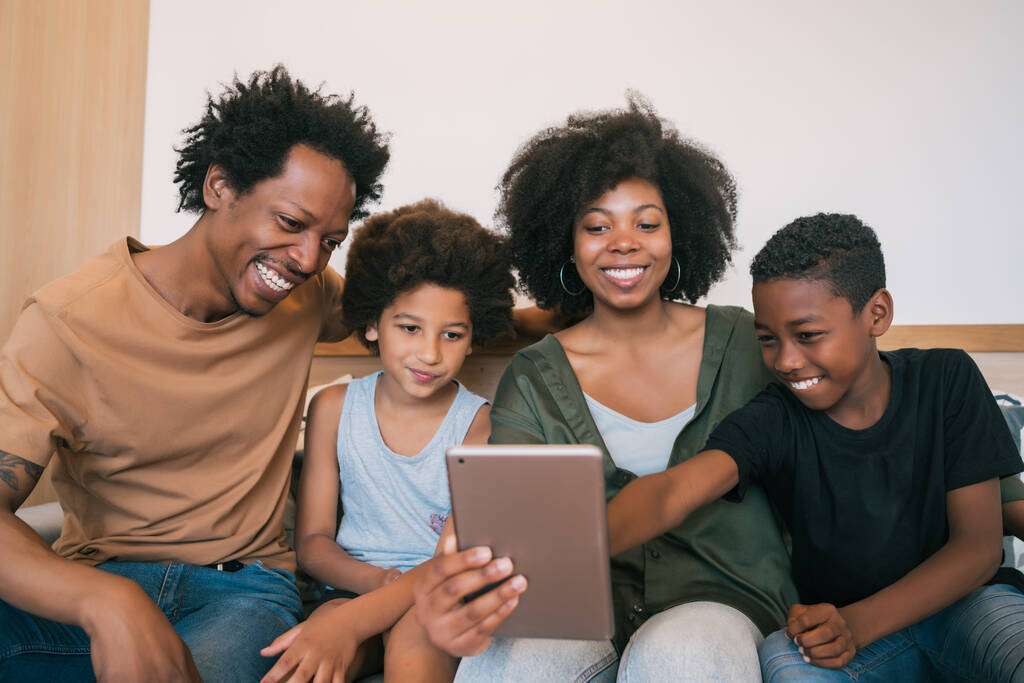 アフリカ系アメリカ人の家族が自宅でデジタルタブレットと一緒に自撮りをしている姿。家族とライフスタイルのコンセプト. - 写真・画像