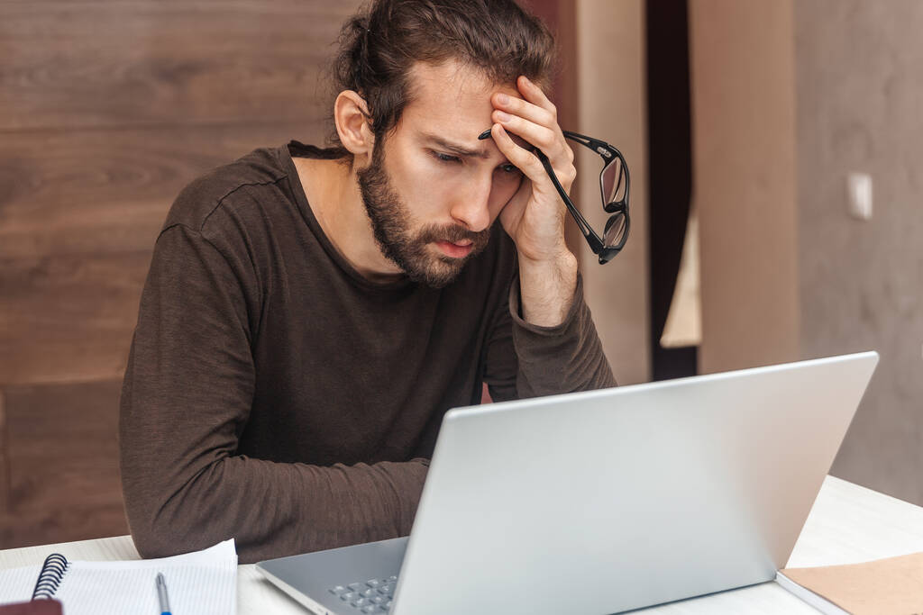 Fáradt ember nézi laptop munka közben - Fotó, kép