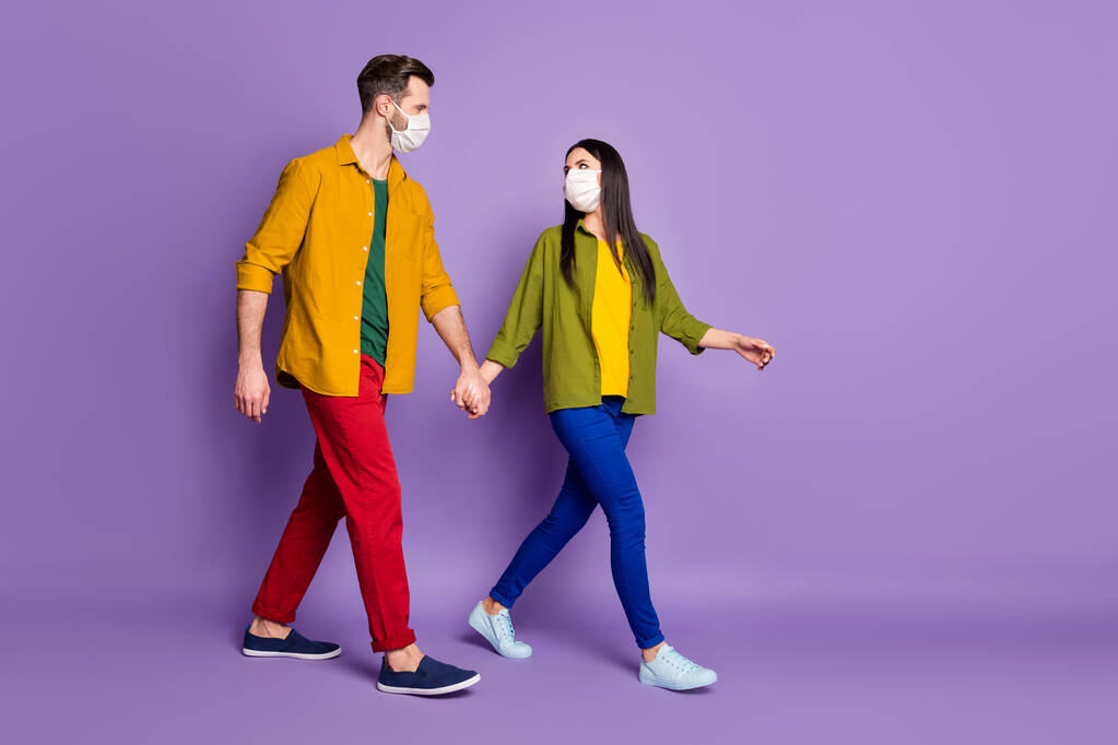 Фотографія профілю красивої леді гарний хлопець тримає руки йти по вулиці до супермаркету, використовуючи респіраторну грип-захисну маску взуття сорочки штани ізольовані фіолетового кольору фону
 - Фото, зображення