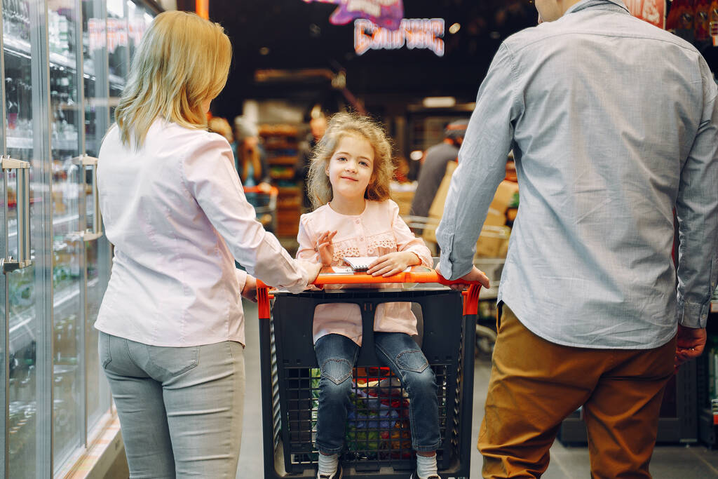 Η οικογένεια αγοράζει ψώνια από το σούπερ μάρκετ. - Φωτογραφία, εικόνα