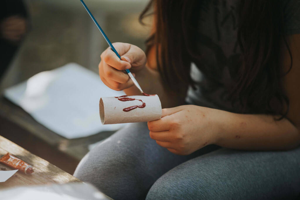 Un primer plano de un niño haciendo una artesanía pintada - Foto, Imagen