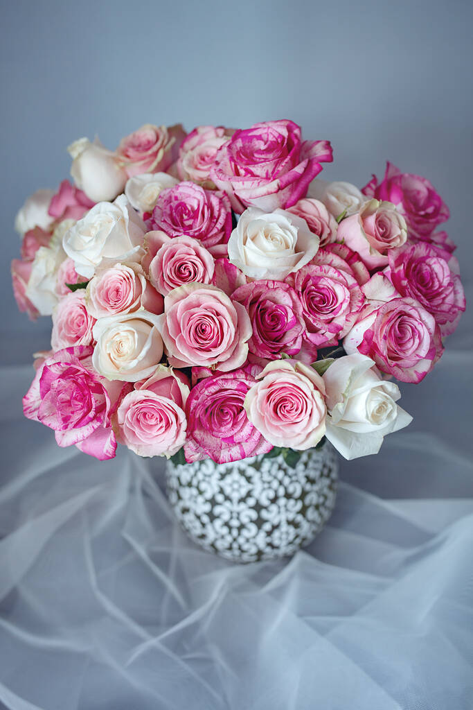 Gyönyörű friss rózsák egy kerámia vázában az asztalon. Lágy fókusz. - Fotó, kép