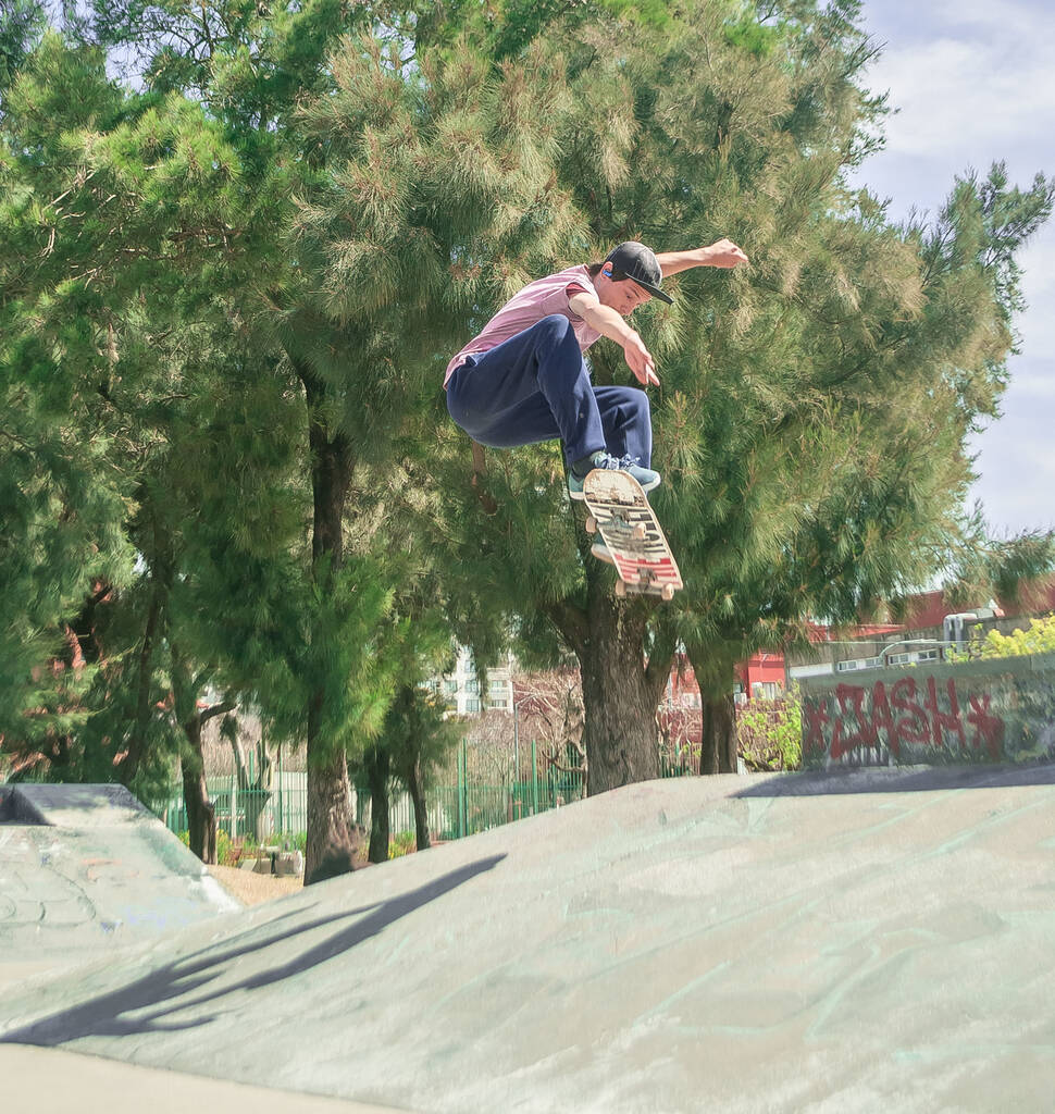Um tiro vertical de um jovem skate em um parque - Foto, Imagem