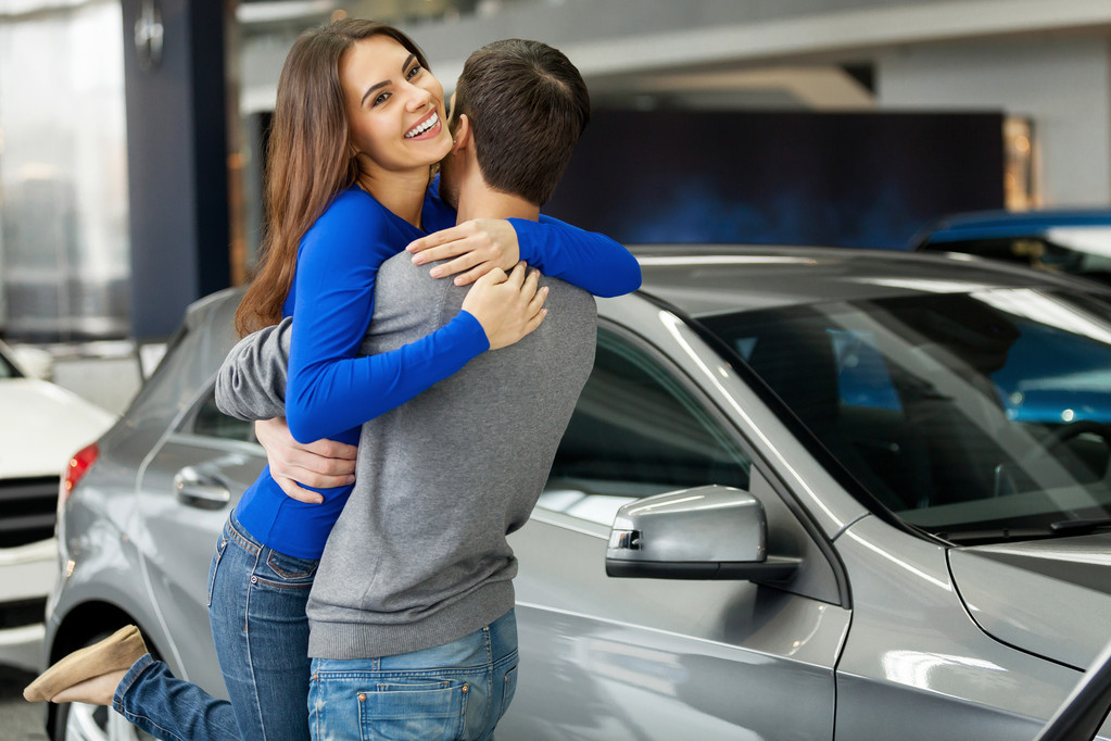 Nainen halaa poikaystävänsä kiitos uudesta autosta
 - Valokuva, kuva