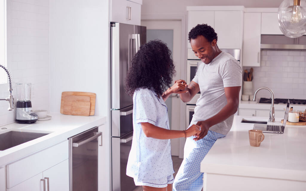 Rakastava pari yllään pyjama ottaa romanttinen tanssi keittiössä kotona yhdessä - Valokuva, kuva