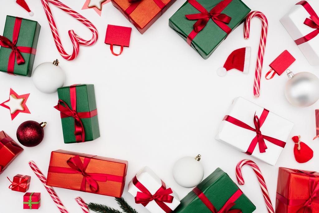 cornice di scatole regalo multicolore, bastoncini di zucchero e palline di Natale su bianco - Foto, immagini