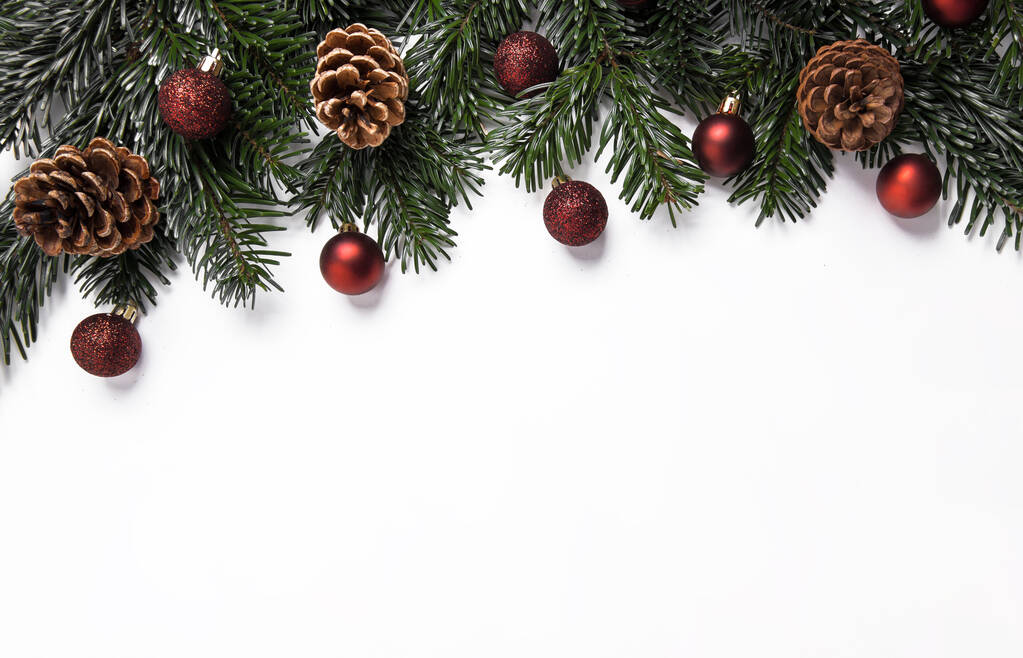 Праздничный рождественский фон с красными безделушками и сосновыми шишками - Фото, изображение