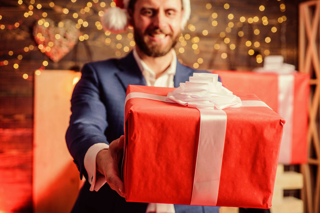 Отпразднуем рождественскую корпоративную вечеринку. Мужчина в костюме держит подарочную коробку. Рождественский подарок от коллеги. Традиция дарить подарки. Бизнесмен взволнованный лицо держать подарочную коробку. Тайная традиция Санты - Фото, изображение