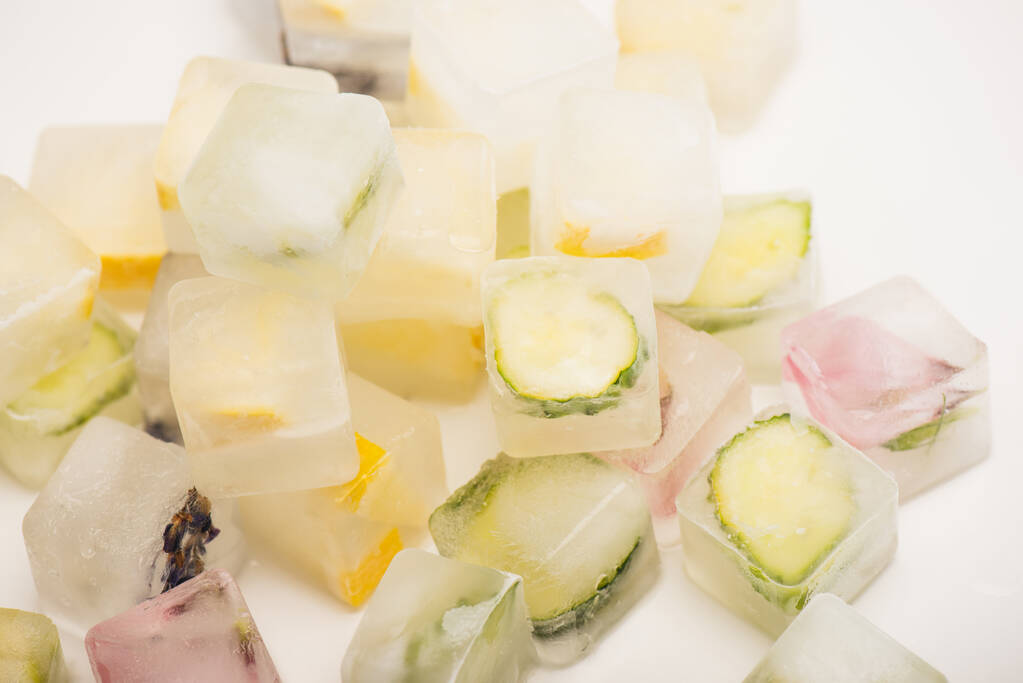 освіжаючі квіткові, овочеві та фруктові кубики льоду для догляду за обличчям на білому
 - Фото, зображення