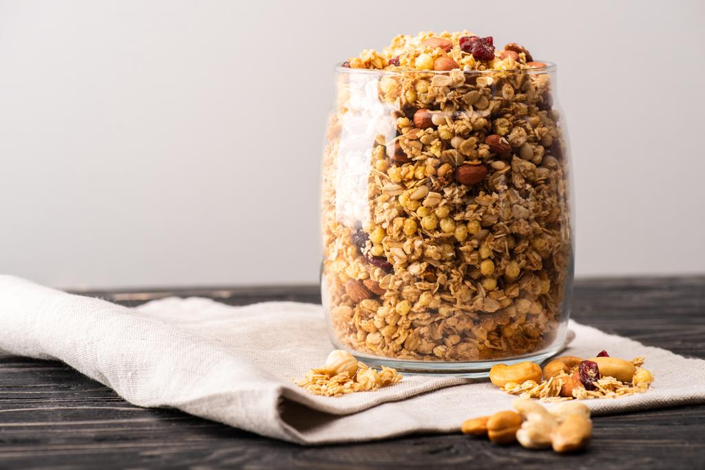 delicious granola in glass gar on napkin isolated on grey - Photo, Image