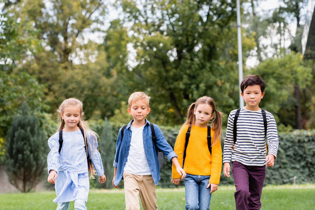 Multiethnic schoolchildren with backpacks walking outdoors  - Photo, Image