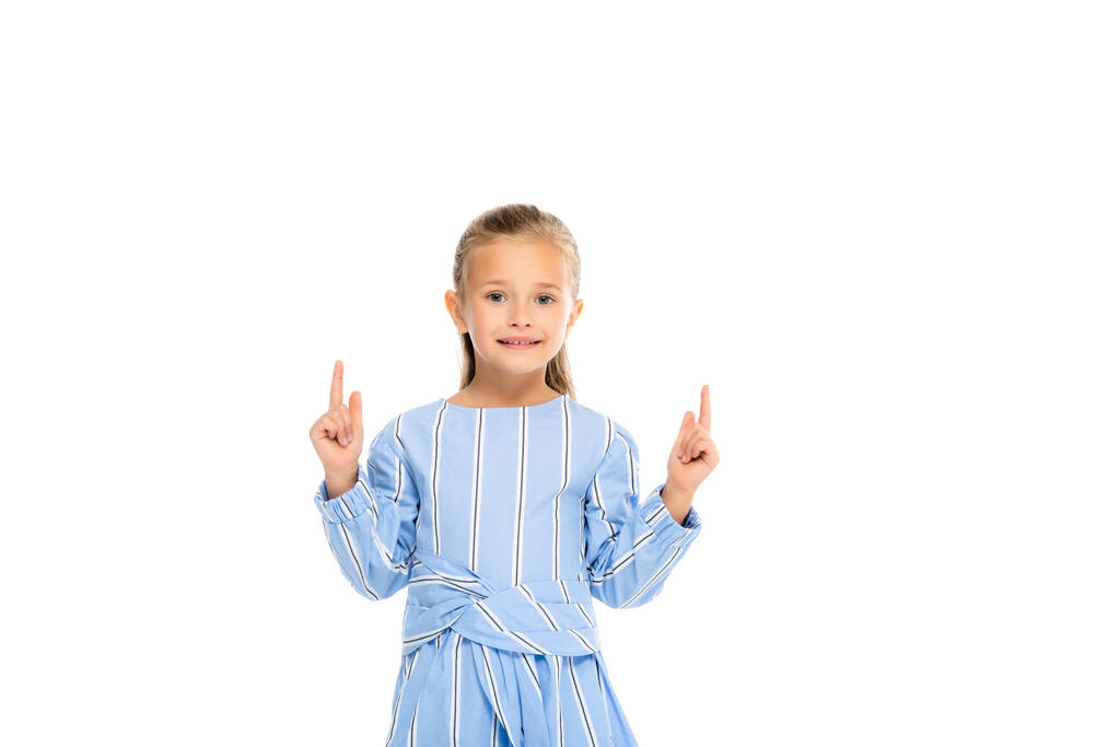 Enfant souriant pointant les doigts vers le haut isolé sur blanc - Photo, image