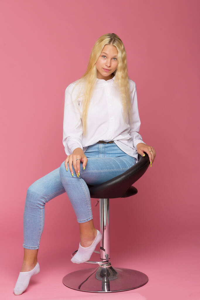 Niedliches Lächeln Blondes Mädchen sitzt auf Hochstuhl im Studio - Foto, Bild