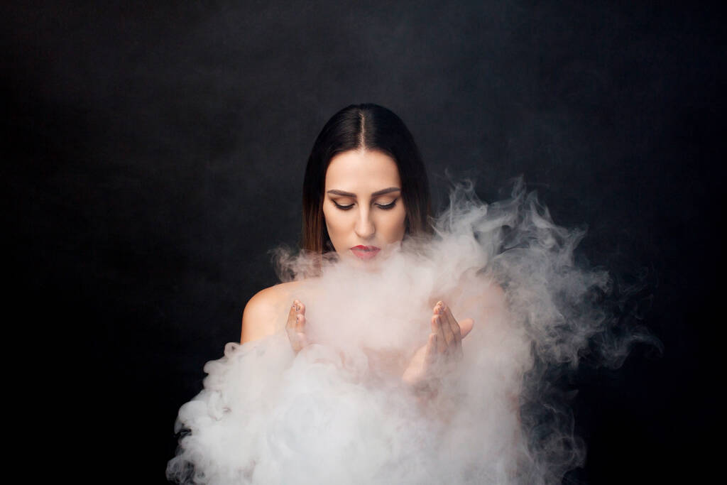 Attractive young girl and white smoke. - Photo, Image