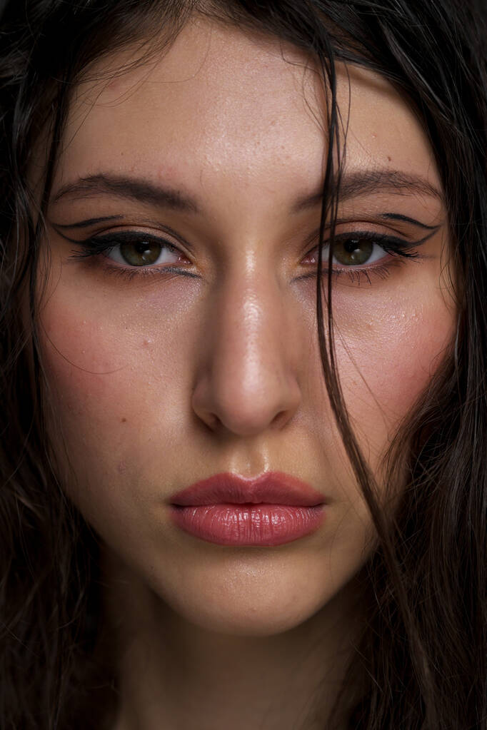 The face of a beautiful young girl with wet black hair close-up. Eastern appearance. Nude makeup, natural skin. - Photo, Image