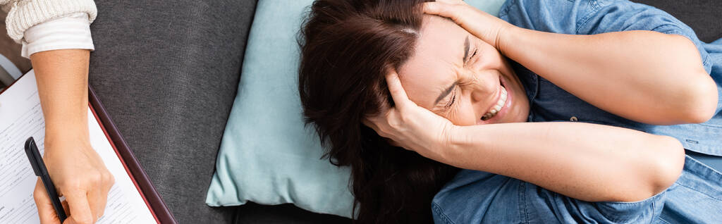 brunette nainen kärsii henkinen ongelma ja puristamalla pää käsissä, banneri - Valokuva, kuva