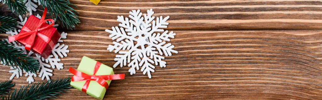 Top näkymä koriste lumihiutaleet, pieni lahja laatikot ja mänty haara puinen tausta, banneri - Valokuva, kuva
