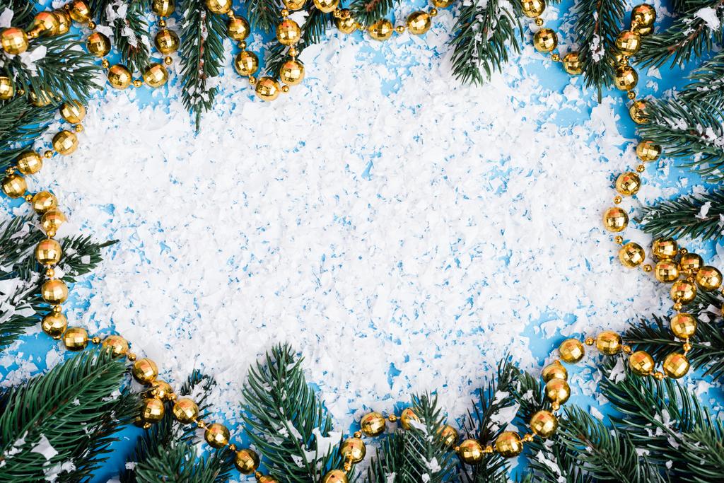 Flat lay with necklace, pine branches and artificial snow on blue background - Photo, Image