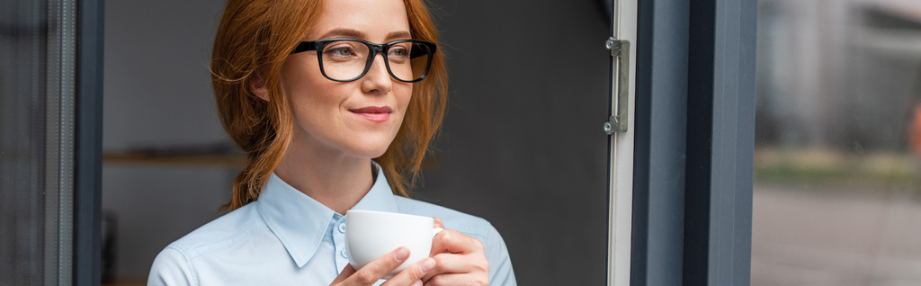 Donna d'affari positiva con tazza di caffè guardando dalla finestra, banner - Foto, immagini