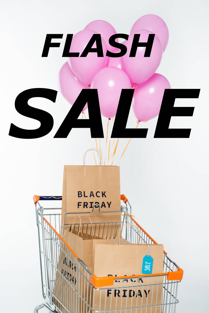 boodschappentassen met zwarte vrijdag in winkelwagen met roze ballonnen in de buurt van flash sale belettering op wit - Foto, afbeelding