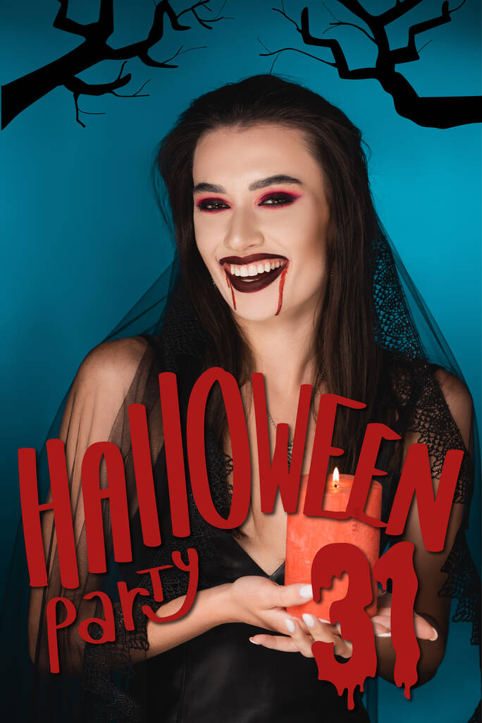 mujer en velo con sangre en la cara sosteniendo vela ardiente roja y riendo cerca de halloween partido letras en azul - Foto, imagen