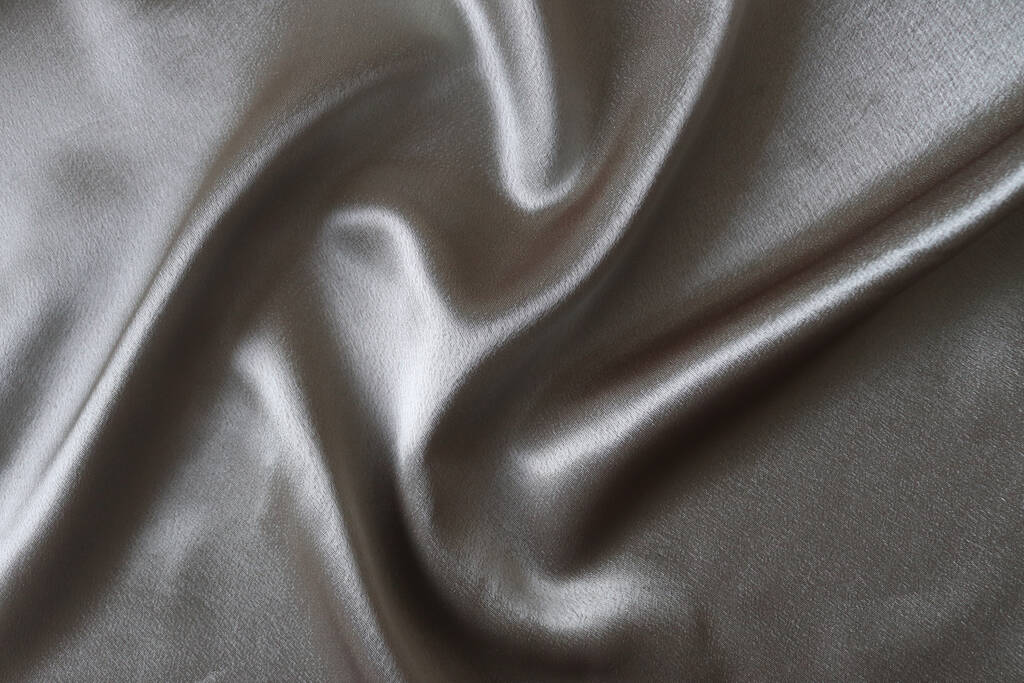 Гладка елегантна срібна шовкова або атласна тканина. Затиснута розкішна текстура тканини для дизайну
. - Фото, зображення