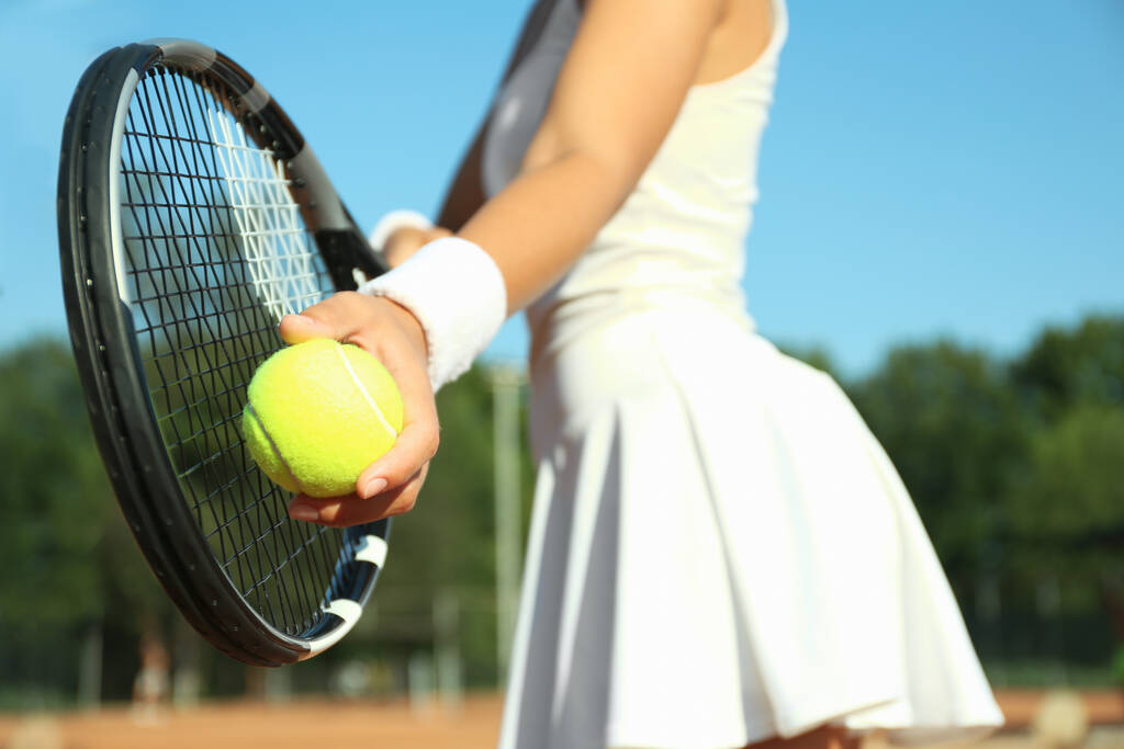 Deportiva preparándose para servir pelota de tenis en la cancha, primer plano - Foto, Imagen