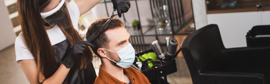Friseur mit Gesichtsschutz und Latexhandschuhen schneidet Haare des Kunden in medizinischer Maske, Banner - Foto, Bild