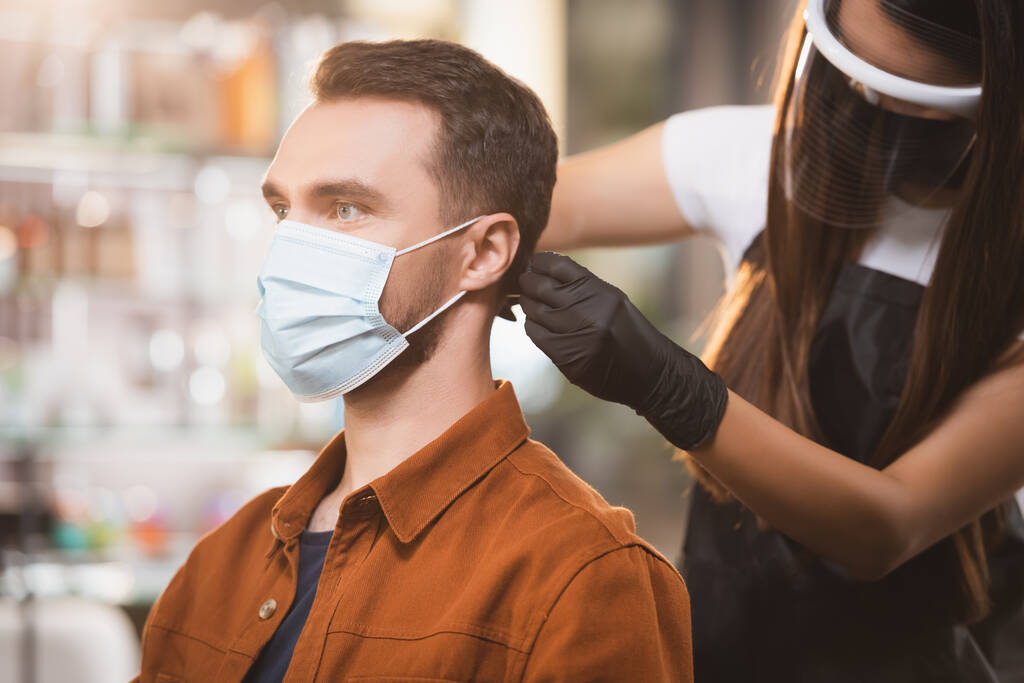 holič v obličeji štít stříhání vlasů člověka v lékařské masce - Fotografie, Obrázek
