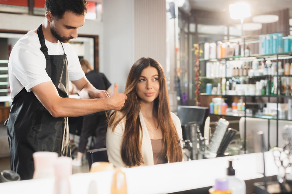 espejo reflejo de peluquero peinando el pelo de la mujer joven, borrosa primer plano - Foto, imagen