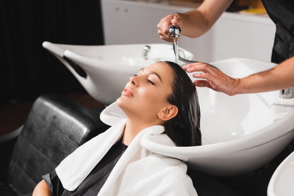 kadeřnice mytí vlasů mladé ženy v holičství - Fotografie, Obrázek