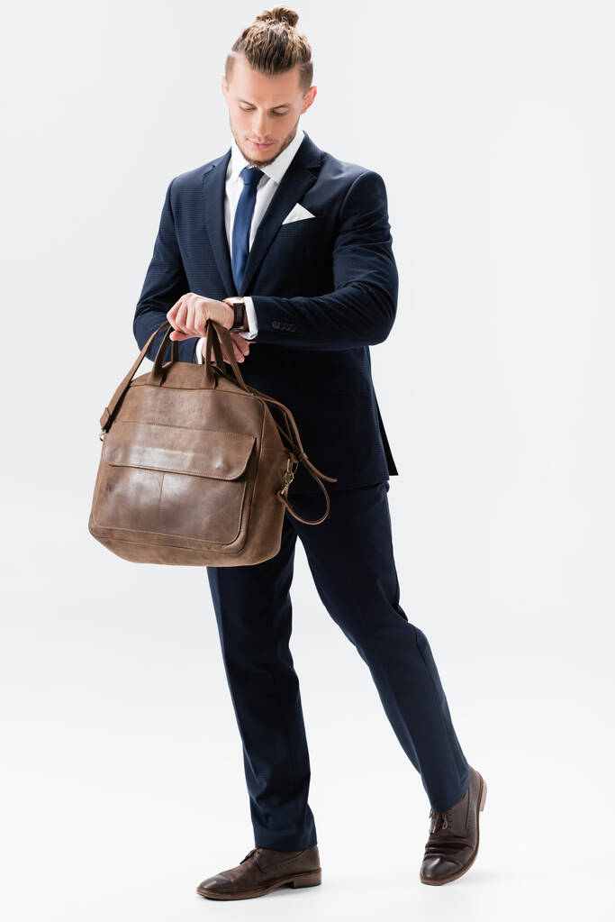 mladý podnikatel v obleku s kufrem izolované na bílém - Fotografie, Obrázek